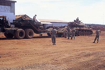 tank approaching low loader